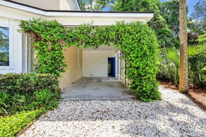 This quaint portico is draped in greenery and jasmine. Door leads to the laundry
