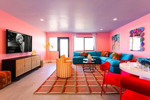 Open living area featuring designer furnishings, a Smart TV, and a dining area with seating for 5 guests.