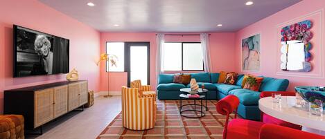 Open living area featuring designer furnishings, a Smart TV, and a dining area with seating for 5 guests.