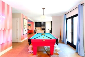 Pool table next to the kitchen and the entrance of the home.