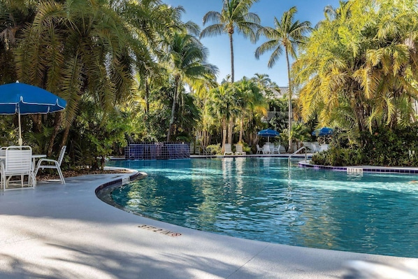 Lounge in bliss by the beautiful lagoon-style pool, surrounded by swaying palms and tropical serenity.