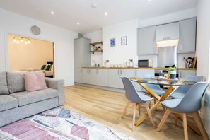 The open-plan living space benefits from a double sofa-bed, a 4-seater dining table and a fully equipped kitchen with everything you need for a short or long-term stay in Manchester.
