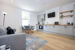 The open-plan living space benefits from a double sofa-bed, a 4-seater dining table and a fully equipped kitchen with everything you need for a short or long-term stay in Manchester.