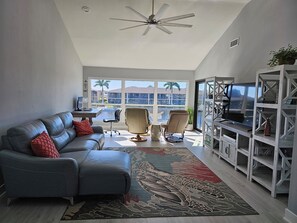 Bright livingroom with valuted ceilings and large windows overlooking the water.