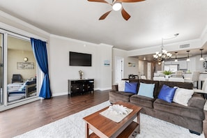Living room looking onto balcony and into dining and kitchen.