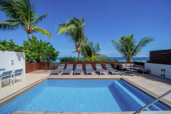 Nice swimming pool surrounded by a spacious and sunny deck with lounge chairs.