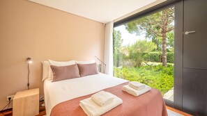 Wake up to floor-to-ceiling windows framing a scenic landscape of trees and natural light. #MorningViews #PeacefulRetreat #Comfort #luxury #portugal #pt #troia