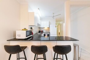 Whip up delicious meals in the well-equipped kitchen, thoughtfully designed for effortless cooking with an oven, dishwasher, large benchtops and bar seating for casual bites.