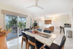 Gather for relaxed meals around the stylish dining table for six, set beneath soft lighting and surrounded by decorative greenery for a touch of tropical calm.
