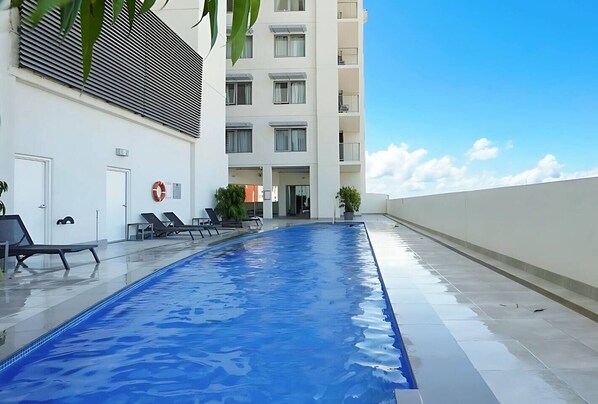 The sparkling shared pool, set on an elevated deck beneath an endless blue sky, is perfect for morning laps or a lazy afternoon float.