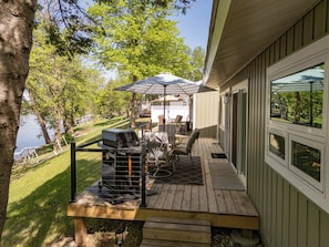 A large deck connecting both cabins with a propane grill and a Blackstone. 