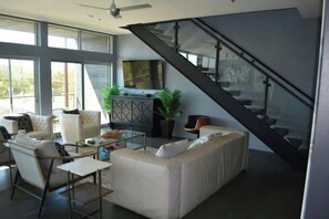 Living room 1 with fold down italian leather sofa, queen size cabinet bed. Internet TV, walls of glass, Pool table, foosball and full kitchen.