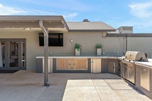 Outdoor kitchen with BBQ grill & TV for the ultimate hangout spot.