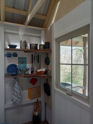 Glamping kitchen, has a washing sink outside and rock firepit with cookgrill