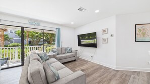 Open concept living area with huge TV and sleeper sofa