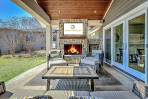 Back patio with outdoor seating, fireplace, and TV