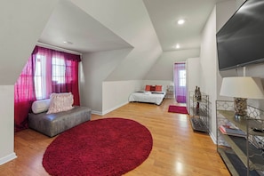 Lounge in the 3rd-floor suite, boasting a full bed, smart TV, & ensuite