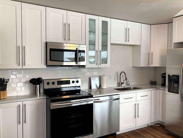 The modern kitchen is fully equipped with high-quality appliances, cookware, tableware, and cutlery, ensuring a seamless cooking experience. Enjoy a stocked Keurig for a fresh cup of coffee anytime.