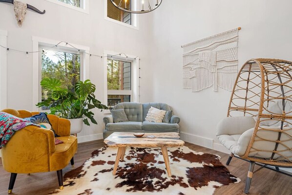 Main floor living room with cozy seating options and access to the deck/balcony space.