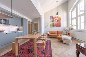 The living room has a 233 cm wide leather sofa that serves as a spare bed.