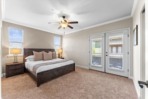 Rest easy in this spacious, sunlit bedroom with direct patio access and a luxurious bed.