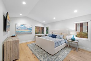 The primary bedroom features a king bed, TV, working space table, and an ensuite bathroom.
