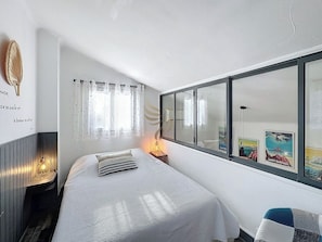 Un espace lumineux et moderne dans un style côtier, parfait pour une relaxation avec vue partielle sur le salon à travers la cloison vitrée. Profitez d'un doux éclairage naturel.