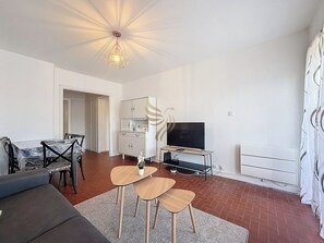 Un salon accueillant avec une décoration minimaliste. La lumière naturelle crée une atmosphère chaleureuse. Idéal pour partager des moments autour de la table à manger.