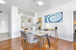  Dine in a modern space with gray chairs, contemporary art, and polished wood floors for stylish meals.
