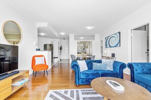 Enjoy a bright, open living space with pops of orange, stylish blue velvet seating, and a modern feel.