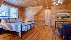Our spacious primary bedroom offers a comfortable retreat with a king-size bed, entertainment, and a spot to relax.