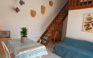 Living room with dining table, sofa and television. 