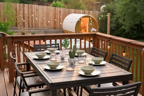 Outdoor dining meets relaxation on this thoughtfully designed deck. With string lights, a cozy seating area, and a charming egg chair, it's the ideal space to relax morning, noon, or night.