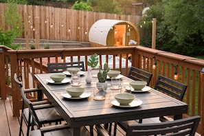 Outdoor dining meets relaxation on this thoughtfully designed deck. With string lights, a cozy seating area, and a charming egg chair, it's the ideal space to relax morning, noon, or night.