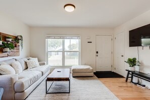 Spacious living area with comfortable seating, smart TV and plenty of natural light