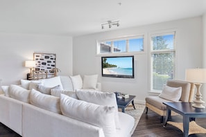 Another angle of the living room highlighting the white sectional sofa, enhancing the space’s light, airy, and welcoming atmosphere.