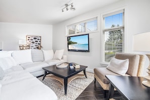 Close up on the living room’s inviting sofa and soft pillows, with a lamp on the side table offering a peaceful corner for reading or quiet moments.