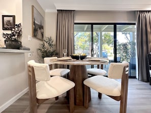 Gather 'round for a relaxing meal or wine tasting at this elegant round table with views of the patio and garden beyond.