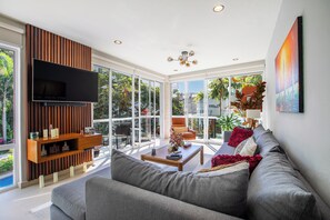 The spacious  and bright living room features a smart TV and comfortable sofa