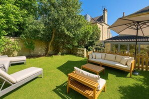 The charming garden boasts a sun-soaked space, perfect for lazy afternoons. Relax on the comfy sofas, read a book in the shade of the leafy trees, or sip your morning coffee. Fully enclosed for privacy and safe for little explorers.