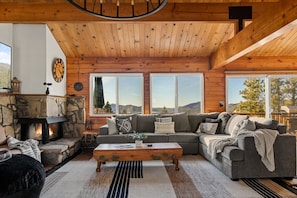 Relax in the living room, enjoying breathtaking views, a cozy wood-burning fireplace, a 65" Smart TV, and a beverage fridge to keep your drinks chilled.