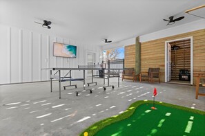 The outdoor entertainment area is sure to be a favorite for all ages! Ping Pong, Smart TV, Cornhole, Putt putt green, Tiki Toss, and outdoor seating. 