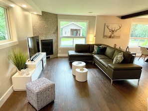 Main living space with 4K TV and comfy leather sectional.