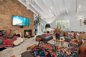 One-of-a-kind living room featuring a lush designer sofa, fireplace, and one of the most comfortable environments you could imagine for watching TV or movies.