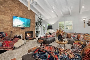 One-of-a-kind living room featuring a lush designer sofa, fireplace, and one of the most comfortable environments you could imagine for watching TV or movies.