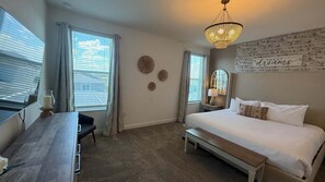 King bedroom with smart TV and large windows