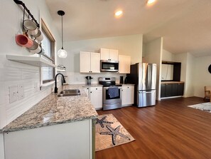 Featuring modern stainless steel appliances with ample counter space.