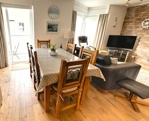Dining and living area with dining table, sofa, tv