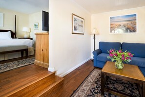 A cozy suite with warm wood flooring and a charming seating area for relaxation.