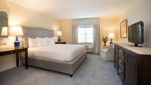 A spacious and serene bedroom with plush bedding, soft lighting, and elegant decor.